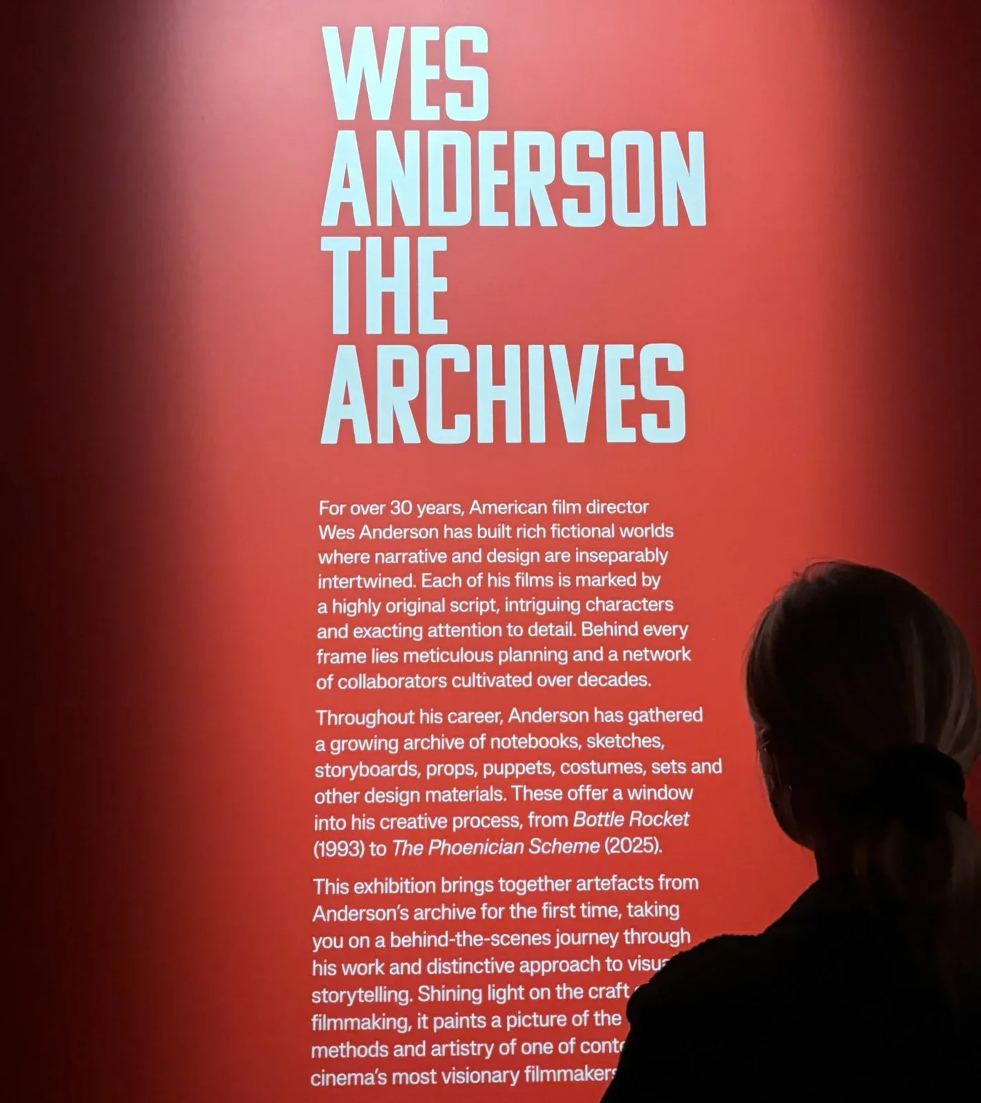 红色标题墙上的Wes Anderson档案展文字和访客